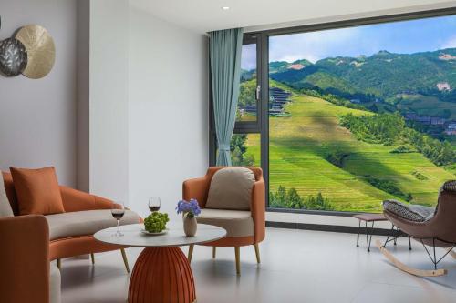 a living room with a large window with a view at Enjoy the panoramic view of the rice fields (Longsheng Longji Terraces Branch) in Heping