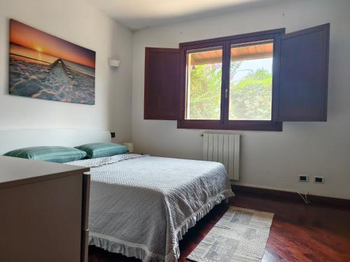 a bedroom with a bed and a window at Villetta del Sole in La Maddalena