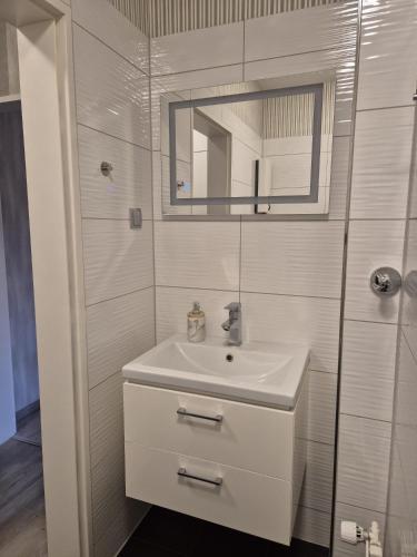 a white bathroom with a sink and a mirror at Studio Apartment in Oberhausen