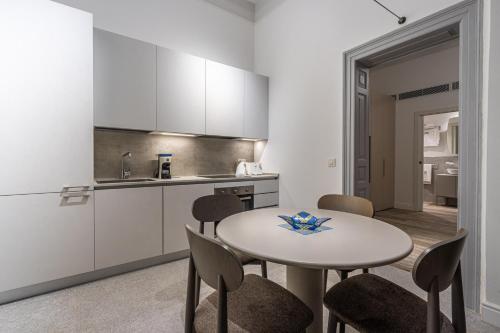 a kitchen with a table and chairs in a room at Old Theatre Suites - Panarea in Valletta