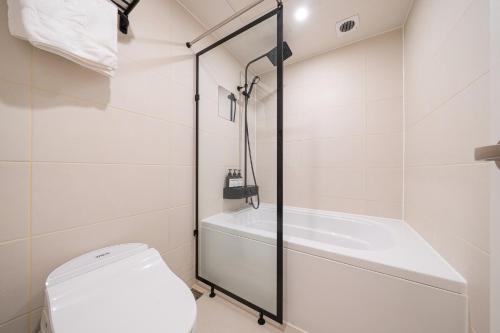 a bathroom with a toilet and a bath tub at No25 Hotel Songnae Station in Bucheon