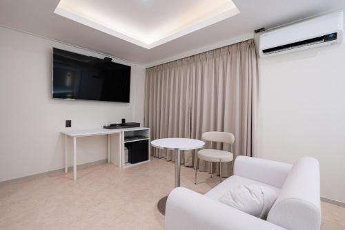 a living room with a white couch and a table at No25 Hotel Songnae Station in Bucheon