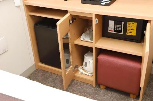 a wooden desk with a drawer and a cabinet with a microwave at KEIKYU EX INN Tokyo Nihombashi in Tokyo