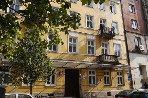 een geel gebouw met een deur ervoor bij Apartamenty Wilcza - City Center in Warschau