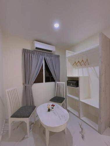 a small room with a table and chairs and a kitchen at Paradise Resort Langkawi in Pantai Cenang