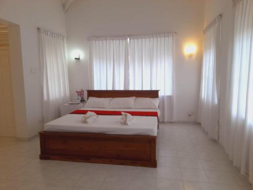 a bedroom with a bed with two white towels on it at Leopard Villa in Negombo