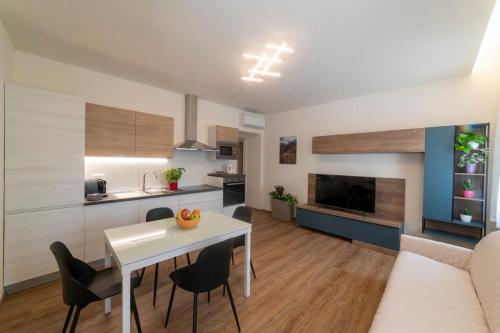 Una cocina y una sala de estar con una mesa y sillas blancas. en EnJoy Home - Appartamento Terra, Il Canterale, en Galzignano Terme