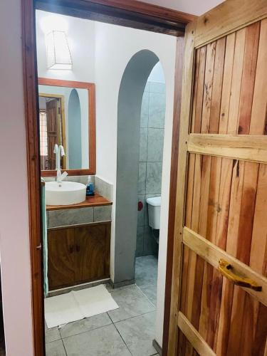 a bathroom with a sink and a mirror at Poa Poa Villas in Watamu