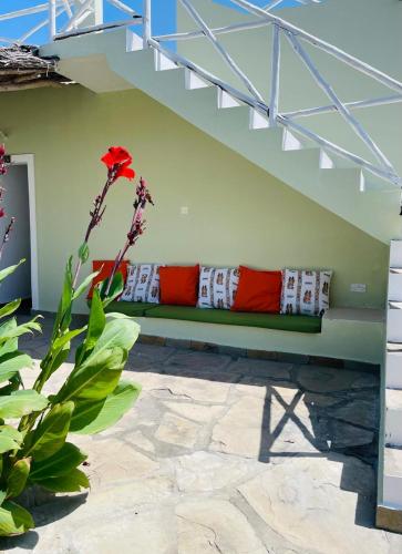 a green couch with red pillows sitting under a stairs at Poa Poa Villas in Watamu