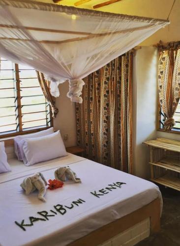 a bedroom with two elephants on a bed at Poa Poa Villas in Watamu