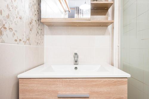 a bathroom with a white sink and a mirror at Joli Appt 2 Centre Village Valloire in Valloire