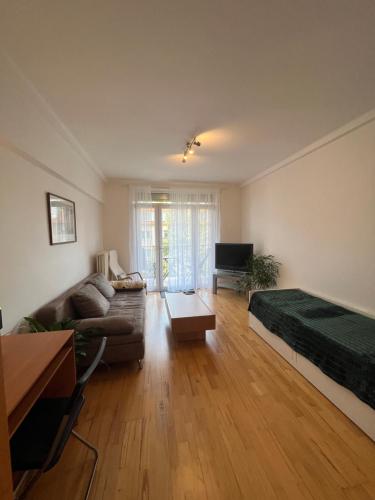 a living room with a couch and a bed and a tv at 2BR Near Nivy & City Center in Nivy