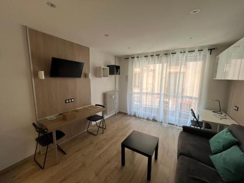 Una sala de estar con un sofá y una mesa con sillas. en L'ecrin du temple, en Aix-les-Bains