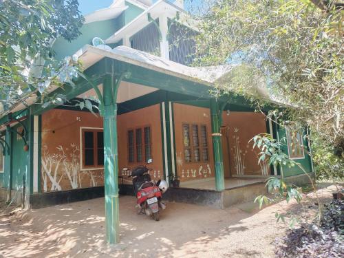 a small house with a motorcycle parked in front of it at Tejana villa in Mananthavady