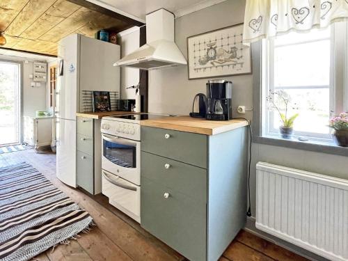 a kitchen with a stove top oven next to a window at 4 person holiday home in FURUBY in Furuby