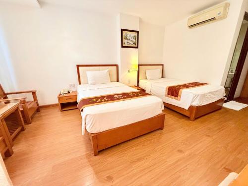 a hotel room with two beds and a piano at Khách sạn Golden Beach Nha Trang in Nha Trang