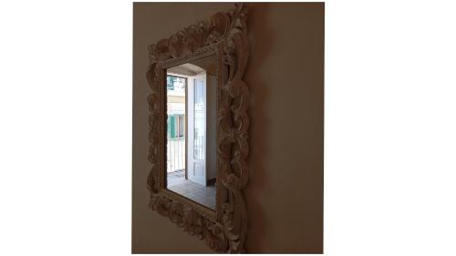 a mirror with a carved wooden frame on a wall at Masi suite in Monopoli