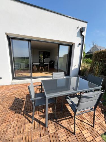 Noyal-PontivyLa villa Pontivyenne的露台上有一张桌子和几把椅子