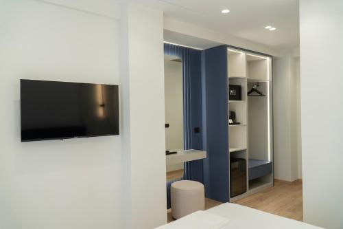 a living room with a tv on a wall at Erdeti Boutique Hotel in Sarandë