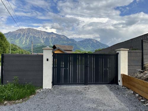 a black gate with a mountain in the background at Chalet Cosy neuf sur terrain privé clôturé 600m2 in Faverges