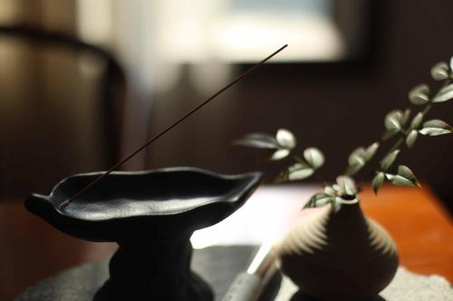 a table with a vase and a plant on it at Dujiangyan Irrigation Project Puruna Hot Spring Hotel Panda Valley Store in Dujiangyan
