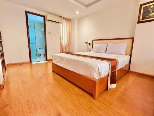 a bedroom with a large bed in a room at Khách sạn Golden Beach Nha Trang in Nha Trang