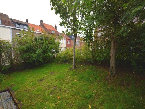 a yard with two trees in the grass at West Flanders Vacation Home in Le Bizet