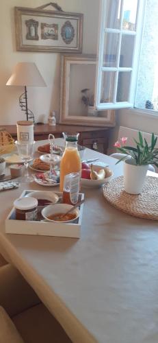 a table with a tray of food and a jug of orange juice at Chambre des Remparts in Lautrec