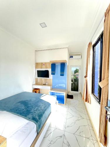 a bedroom with a bed and a desk in it at Hotel Asia Express in Lembang