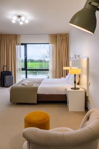 Un dormitorio con una cama y una ventana grande. en Via Vitalité, en Aizpute