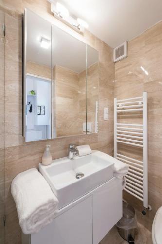 a bathroom with a white sink and a mirror at Bridge & Castle Art Apartman in Budapest