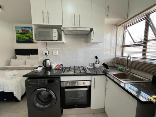 a kitchen with a sink and a stove top oven at The studios at Forest Glen in Johannesburg