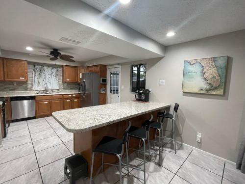 a kitchen with a counter and bar stools at Pool Home at Busch Gardens USF in Tampa