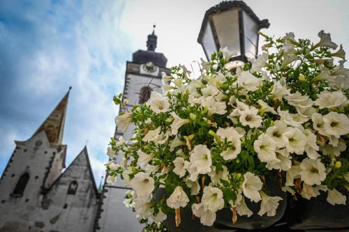 a bouquet of white flowers hanging from a clock tower at Ubytování v srdci Písku in Písek