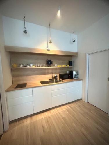 a kitchen with white cabinets and a sink at Ubytování v srdci Písku in Písek