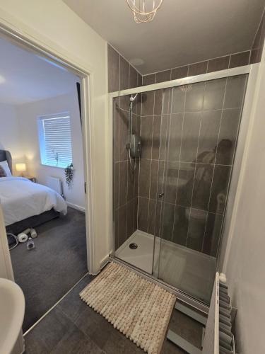 a bathroom with a shower with a bed and a shower at The Charm Luxury House - 8mins to NEC, Birmingham Airport in Marston Green