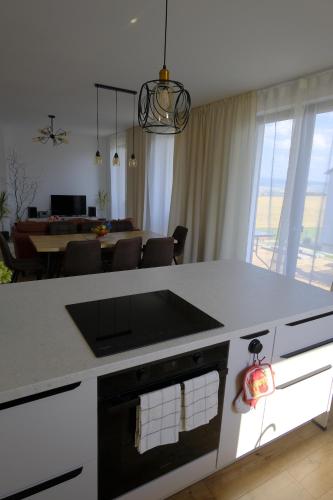a kitchen with a white counter top and a living room at Červene maky - red poppies in Malý Slavkov