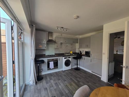 a large kitchen with white appliances and a table at The Charm in Marston Green