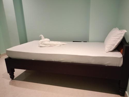 a bed with a stuffed animal sitting on top of it at Muns Hotel in Bongaigaon
