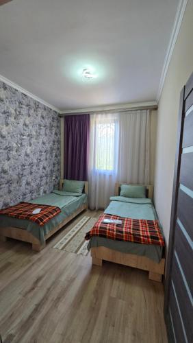 a bedroom with two beds and a window at Start Rest House in Hrazdan