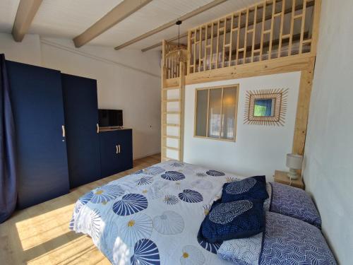 a bedroom with a bed with a blue and white comforter at Maison familiale à Barbâtre face à la dune, 3 chb, 2 SDB, 8 personnes in Barbâtre