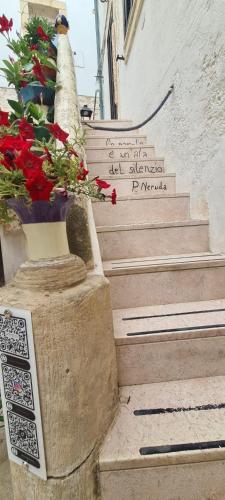 a set of stairs with flowers on the side of a building at Mare e Relax in Mola di Bari
