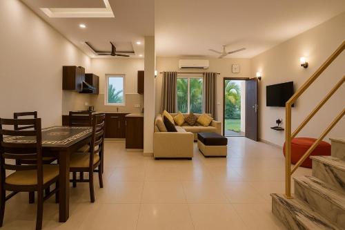 a living room and kitchen with a table and a couch at The Garnet Resort - Top Rated & Most Awarded Property in Vrindavan in Vrindāvan