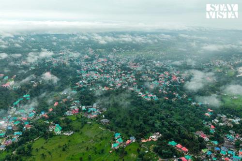 an aerial view of a city on top of a mountain at Vaikunth Villa by VEO - Part of StayVista in Pālampur