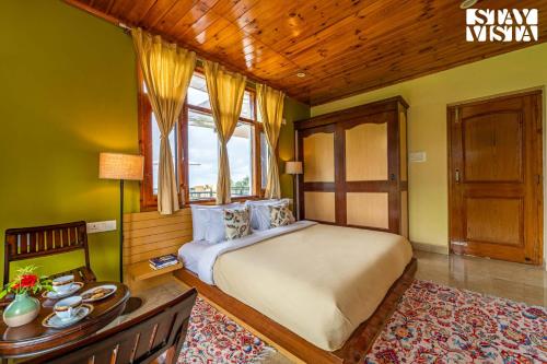 a bedroom with a large bed and a window at Vaikunth Villa by VEO - Part of StayVista in Pālampur