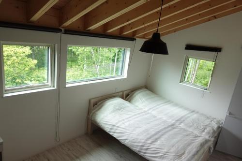 a small bedroom with a bed and two windows at CLOUD9 - Vacation STAY 46105v in Rusutsu
