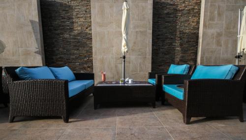 a patio with two chairs and a table with blue pillows at Novotel Yanbu Albahr in Yanbu