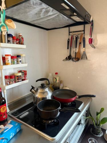 a kitchen stove with two pots and pans on it at 童童民宿 in Tokyo