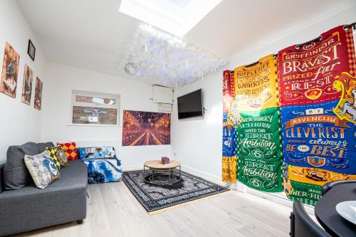 a living room with a couch and posters on the wall at The Grand Hogwarts Suite A Magical Experience in Leavesden Green