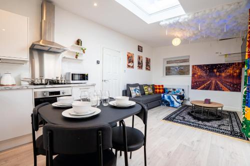 a kitchen and living room with a table and chairs at The Grand Hogwarts Suite A Magical Experience in Leavesden Green